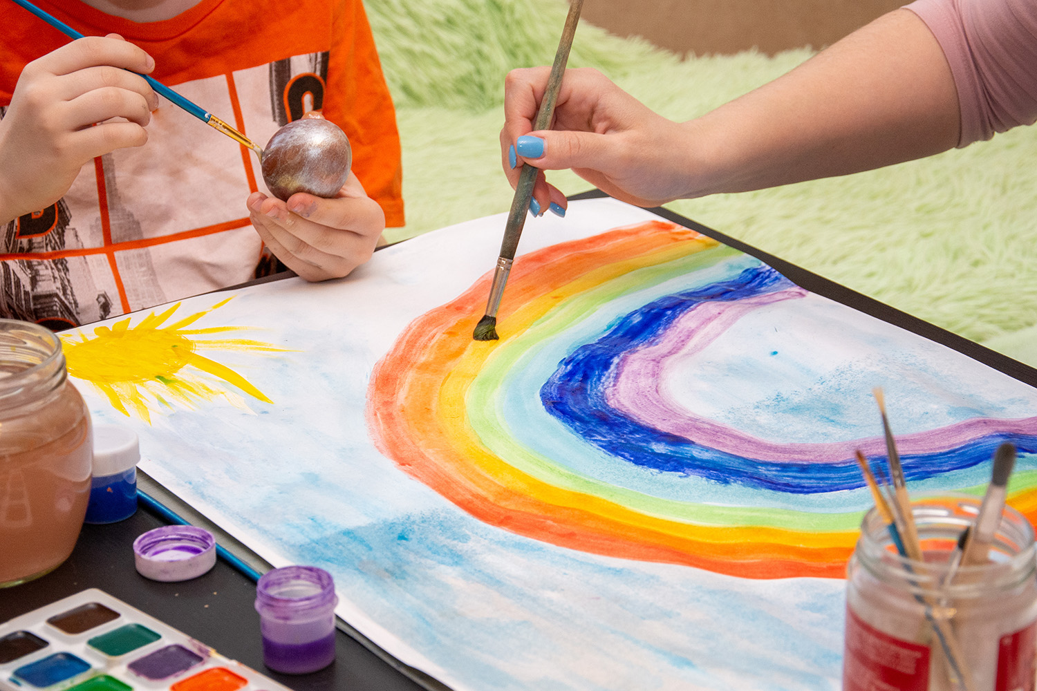 Child painting a rainbow during a play therapy session in Denver with Registered Play Therapist, Alyssa Meyer, LCSW, RPT