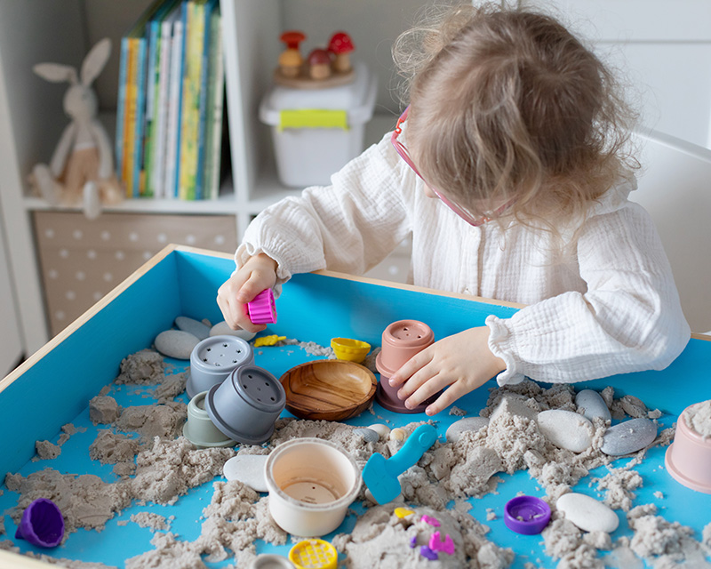 Child playing with a sand tray