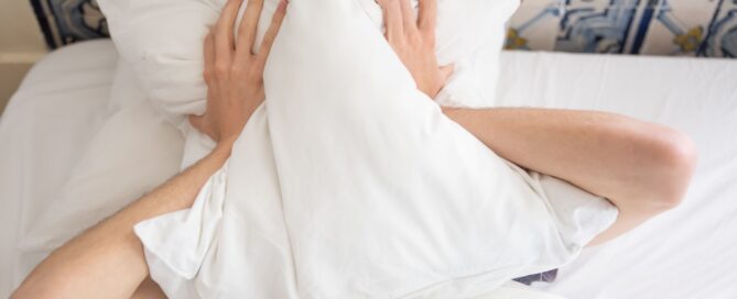Illustration of a person lying awake in bed with racing thoughts, representing why the brain won't shut off when exhausted.