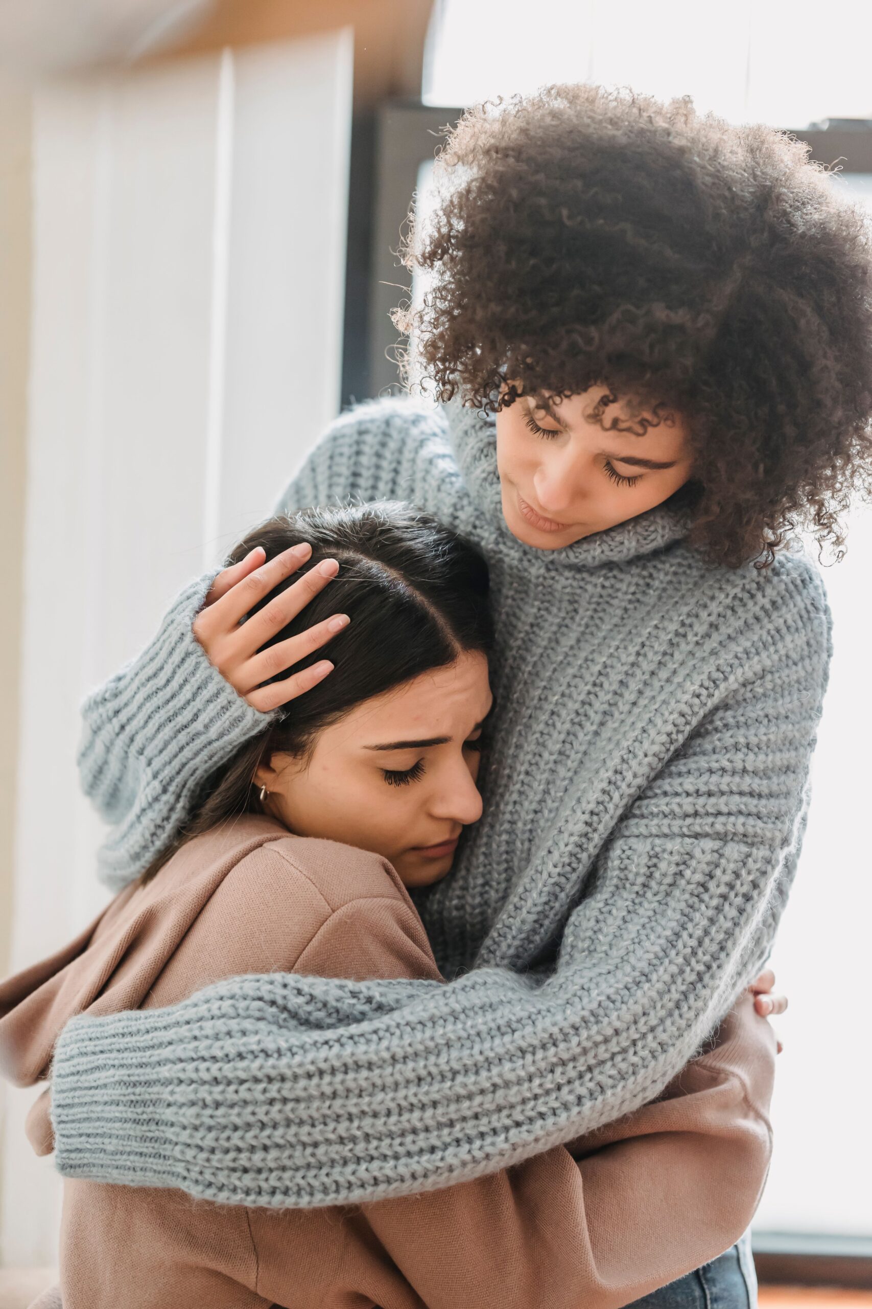 Two people hugging while grieving